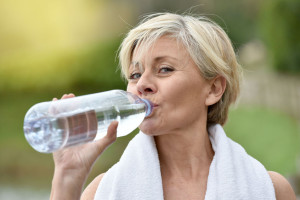 48551900 - senior woman drinking water after exercising