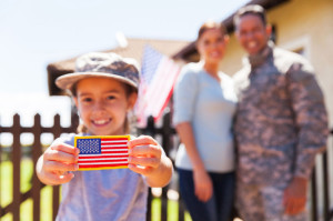50864636 - little girl holding american flag badge in front of parents