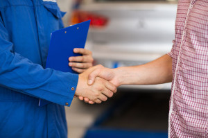 72745744 - auto mechanic and man shaking hands at car shop