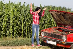 42260186 - young attractive girl standing beside broken car at rural road