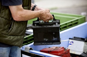 64792949 - a senior man recycling a car battery
