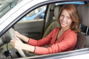 20137276 - photo of cute woman sitting in a new car and looking at camera