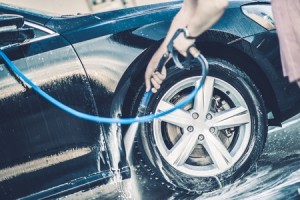 37860553 - self car washing. cleaning wheels using high pressure water.