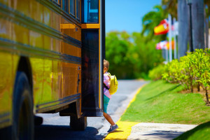 44953714 - young boy, kid getting on the schoolbus, ready to go to school