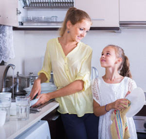 51765568 - everyday routine: girls doing and wiping dishes in kitchen