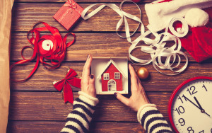 48654891 - female hands are wrapping a christmas gift on wooden background