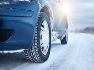 51577068 - closeup of car tires in winter on the road covered with snow