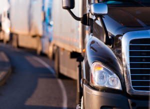 25858137 - details of dark semi truck on the road on blurred truck and trailer