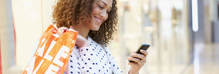 42307364 - woman in shopping mall using mobile phone