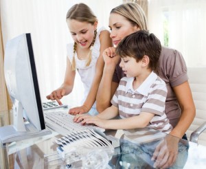 10095713 - attentive mother teaching her children how to use a computer