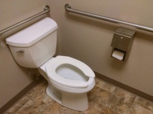 46035214 - the corner of a public restroom with a wheelchair accessible toilet.