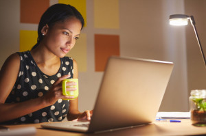 54728331 - a young woman working on her laptop in her office at night