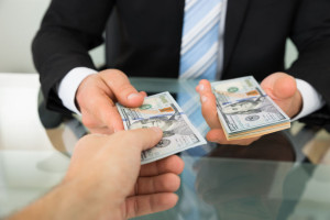 35462167 - cropped image of businessman passing money to colleague at table