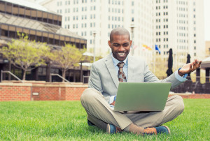41067379 - a smiling man with laptop outdoor reading good news email