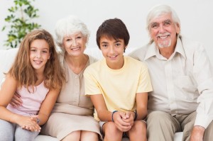 18118399 - happy grandparents with grandchilden on sofa