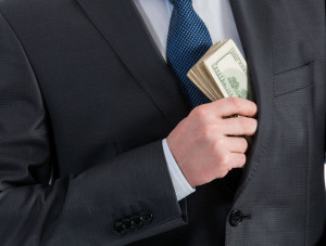 49258230 - businessman putting money in his pocket - closeup shot