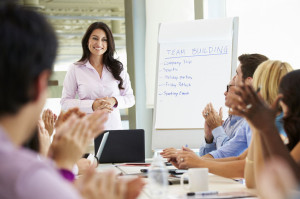 31047571 - businesswoman addressing meeting around boardroom table