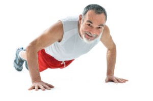 9085792 - senior man doing push-ups exercise in gym.