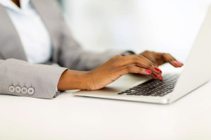 30591262 - close up of african businesswoman hands working on laptop