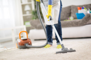 54016312 - housewife from cleaning service cleans carpet with vacuum cleaner