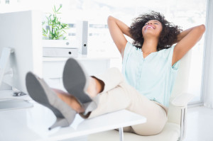30979423 - happy businesswoman sitting with her feet up in her office