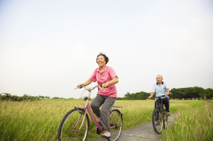 32624106 - happy asian elderly seniors couple biking in the park