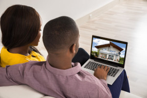 56277508 - young couple looking at house on laptop's screen