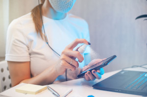 Woman disinfects the surface of the phone