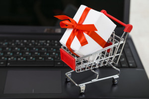 Shopping cart with gift box on laptop. Concept of shopping onlin