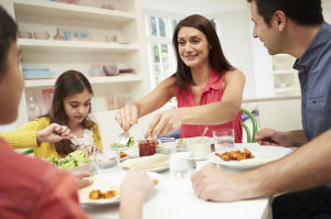 31013731 - hispanic family sitting at table eating meal together