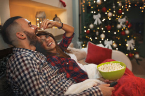 87287288 - couple in love at christmas eve enjoy with popcorn while watching tv