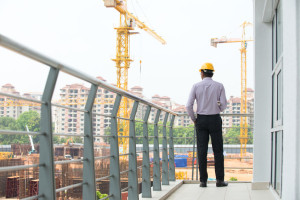 29265797 - indian male engineer inspecting site with construction background