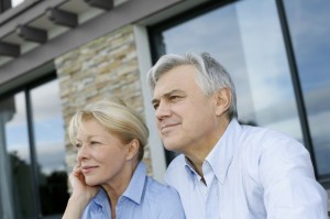 16397528 - senior couple sitting in front of house and looking away