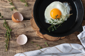 Scrambled eggs in an iron pan on the rustic table