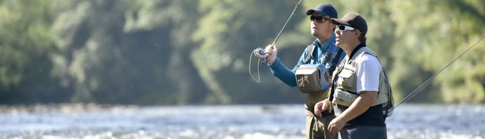 Flyfisherman with fishing guide in river