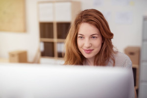 Pretty young woman working on a desktop computer