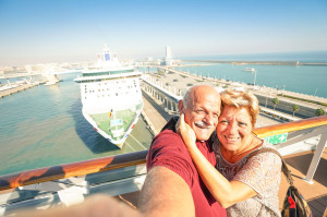 Senior happy couple taking selfie on ship at Barcelona harbour b