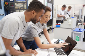 Two Engineers Using CAD Programming Software On Laptop