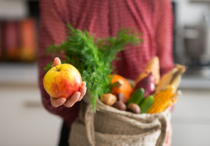 Closeup on young housewife showing apple