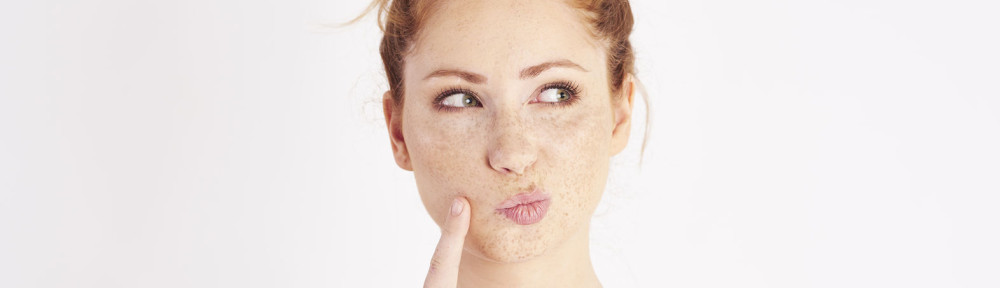 Woman with hand on chin thinking at studio shot