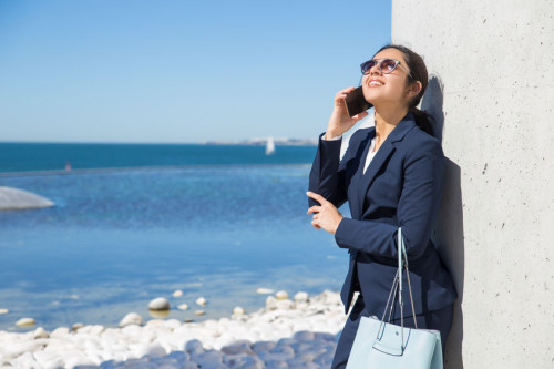 Cheerful manager chatting on phone during work break