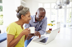 Mature African American Couple Using Laptop At Breakfast