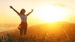 Happy woman   on sunset in nature iwith open hands