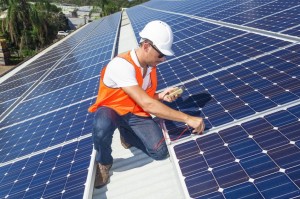 21361828 - young technician checking solar panels on factory roof