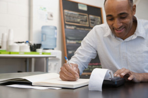 Man doing accounts in cafe