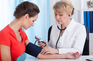 Taking blood pressure of female patient