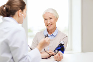 doctor with tonometer and senior woman at hospital