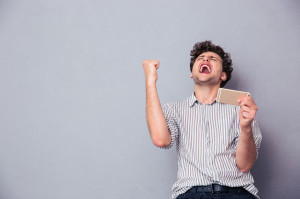 Man holding smartphone and celebrating his success