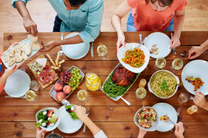group of people eating at table with food