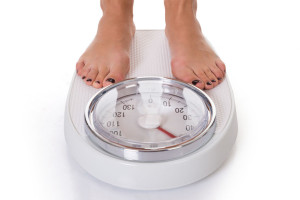 Low Section Of Woman Standing On Weighing Scale